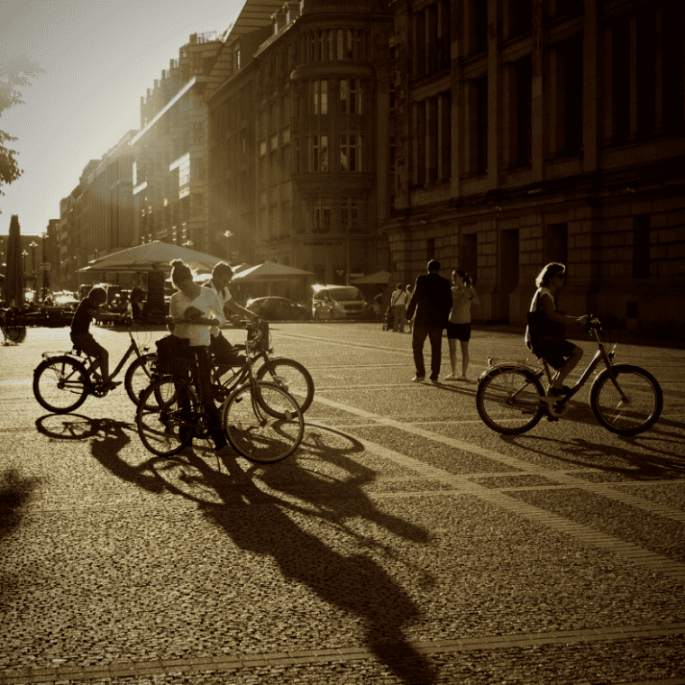 a vintage photo of a man riding a bicycle on a street