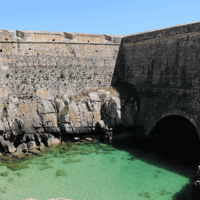 a stone building that has a bridge over water