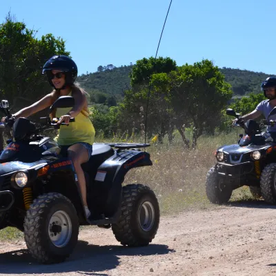two people riding quad bikes
