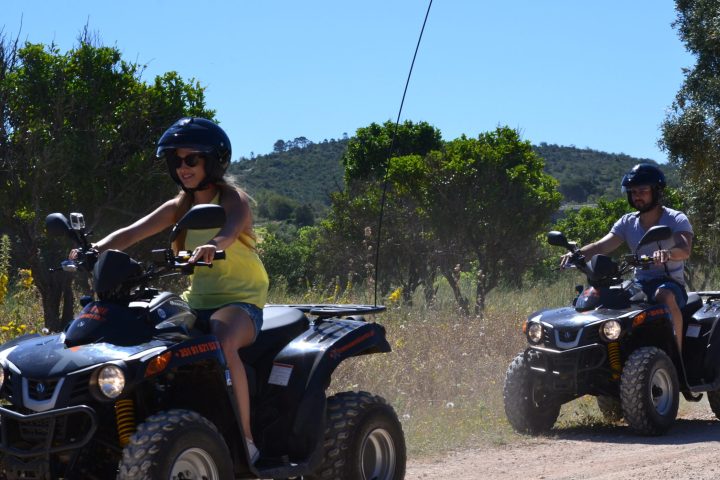 two people riding quad bikes