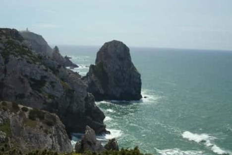 a rocky island in the middle of a body of water