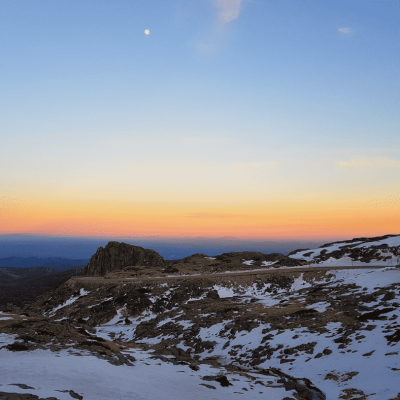 a sunset view from a snowy mountain