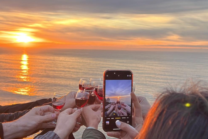 a person holding a glass of water on a beach