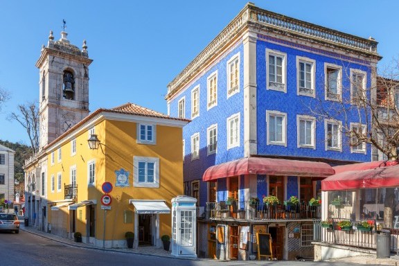 Colorful buildings and a bell tower under a clear blue sky.