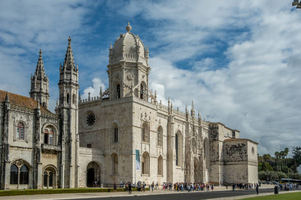 Large, ornate Gothic-style cathedral with a dome on a sunny day with blue sky and clouds.