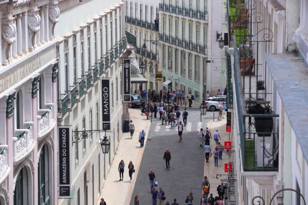 Aerial view of a bustling city street lined with shops and pedestrians.